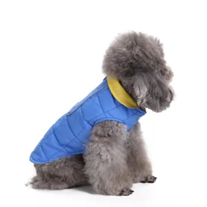 Side view of warm blue quilted puffer dog vest with yellow collar on a grey poodle