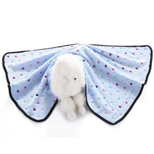 Detailed view of the soft blue pet blanket featuring colorful polka dots and a plush toy dog.