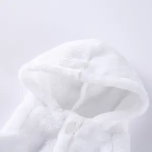 Close-up of white plush pet bathrobe with hood and snap button detail