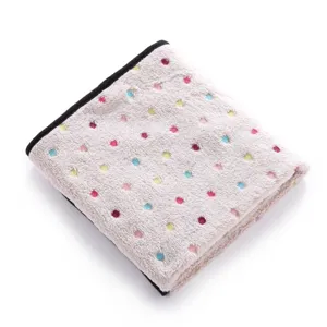 Detailed view of the soft fleece pet blanket featuring colorful polka dots and black edge trim.