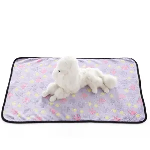 Detailed view of fluffy pet blanket featuring colorful paw print patterns and black edge trim.