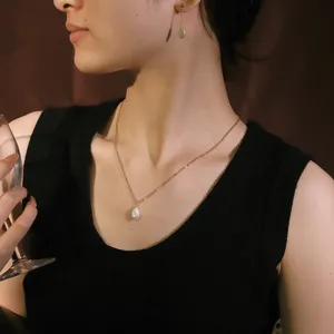 Elegante conjunto de collar y pendientes de perlas barrocas en una modelo asiática.