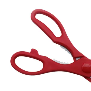 Macro view of red ergonomic handles and serrated center on stainless kitchen scissors