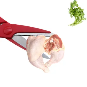 Heavy-duty red handle stainless steel kitchen shears cutting through raw chicken legs.