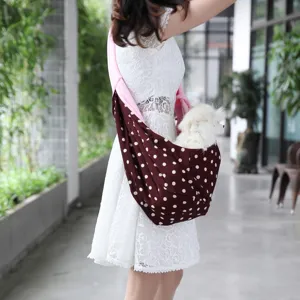 Portable dog carrier sling bag with stylish polka dot pattern for outdoor travel and pet walking.