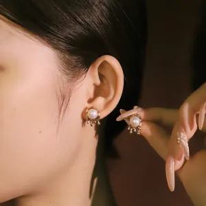 Eleganti orecchini a perno dorati irregolari con perle naturali e design fuso