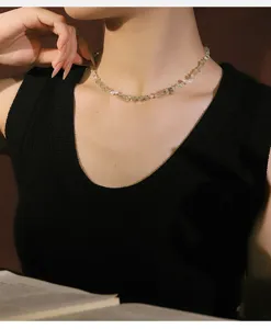 Primer plano de un elegante collar de perlas naturales y prehnita usado por una modelo