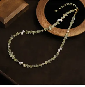 Primer plano de un collar hecho a mano con trozos de prehnita verde y perlas