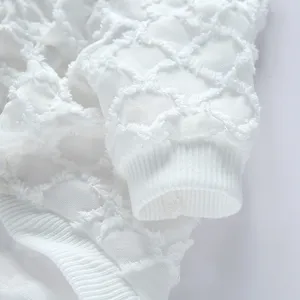 Primo piano di indumento bianco per animali con polsini a costine e motivo jacquard