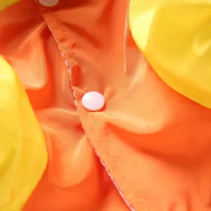 Gros plan sur le tissu de l'imperméable pour chien avec design jaune et orange imperméable.