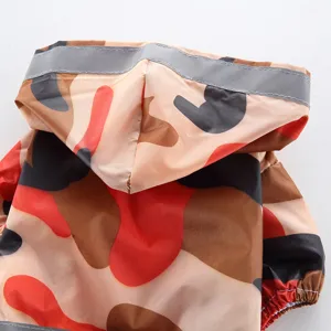 Détail d'imperméable pour chien camouflage avec capuche et bande réfléchissante.
