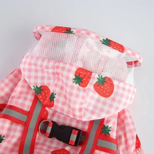 Vue rapprochée détaillée du joli imperméable pour animaux motif fraise avec capuche transparente.