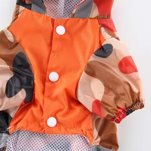 Détail d'imperméable pour chien motif camouflage orange, boutons blancs et doublure filet.