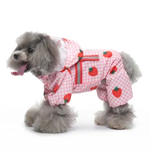 Détail d'imperméable rose à carreaux fraise pour chien, design quatre pattes avec bande réfléchissante.