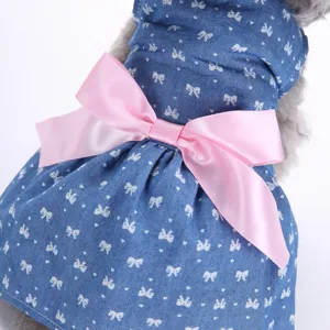 Detaillierte Nahaufnahme eines blauen Jeans-Haustierkleids mit großer rosa Schleife.
