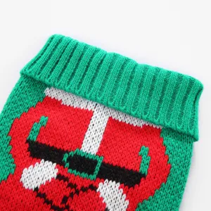 Gros plan detaille d'un pull de noel pour animal avec motif de pere noel et col roule vert.