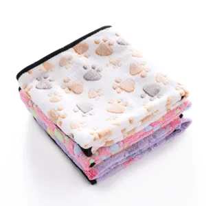 Soft plush pet blanket detail showing cute paw print pattern and folded texture layers.