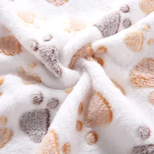 Detailed close-up view of a soft plush pet blanket featuring cute paw print patterns and cozy fabric.
