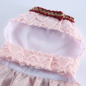 Vue de détail d'une robe pour animal en tulle rose, bordure tressée et fermeture velcro.