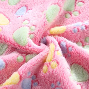 Soft pink pet fleece blanket close-up detail showing colorful cute paw print pattern texture.