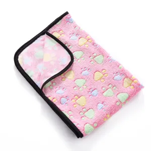 Soft fleece pet blanket with colorful paw print design and black binding for dogs and cats.