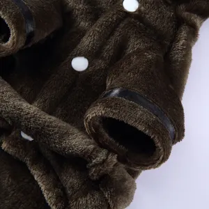 Close-up detail of soft brown plush pet bathrobe with white buttons and black trim.