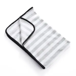 Detailed view of a soft grey and white striped pet fleece blanket with black edge binding.