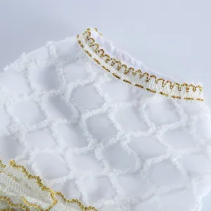Vue détaillée d'une robe pour chien blanche avec col bordé d'or élégant et tissu en maille.