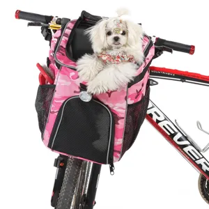 Piccolo cane bianco in una borsa rosa mimetica per bici per animali fissata al manubrio