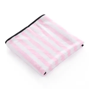 Close-up detail of soft pink and white striped pet blanket with neat black binding edge.
