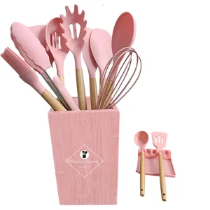 Silicone kitchen utensil set with wooden handles, 13-piece pink cooking tools with holder.