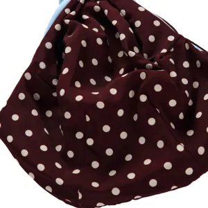 Pet sling bag detailed fabric view featuring stylish red polka dots and blue lining.
