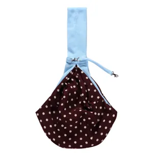 Detailed view of the pet sling carrier bag featuring a brown polka dot pouch and blue strap.