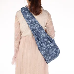Rückansicht einer blauen Haustier-Tragetasche mit Blumenmuster auf einem Spitzenkleid