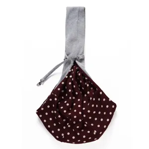 Breathable pet sling carrier detail, stylish maroon polka dot fabric and adjustable grey strap.