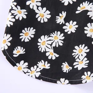 Nahaufnahme eines Sommer-Strandhemdes für Haustiere aus schwarzem Stoff mit Gänseblümchen-Print.