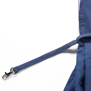 Close-up detail of the durable blue denim shoulder strap and metal clasp on pet carrier bag.
