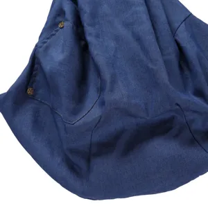 Blue denim pet bag detail view featuring durable fabric, pocket and metal rivet buttons.