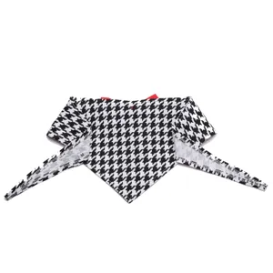 Detailopname van het zwart-witte houndstooth dierenbandana met rood accent in maat M.