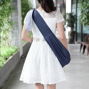Detail shot of a denim pet sling carrier, comfortable cross-body dog bag for outdoor travel use.