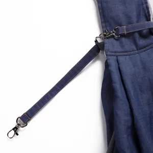 Breathable pet carrier backpack strap detail, durable denim fabric with sturdy metal clasp.