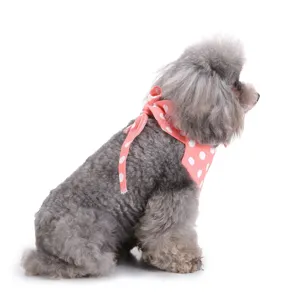 Gedetailleerde close-up van een hond met roze gestippelde huisdier slabbetje, zachte stof.
