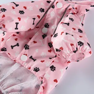 Gros plan d'un adorable imperméable rose pour chien avec des motifs de pattes et d'os.
