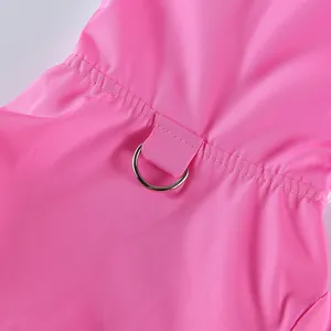 Gros plan d'un imperméable rose pour animal de compagnie en tissu imperméable avec un anneau en D.