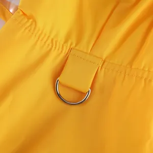 Détail de l'imperméable pour animal avec tissu imperméable jaune et anneau en D métallique.