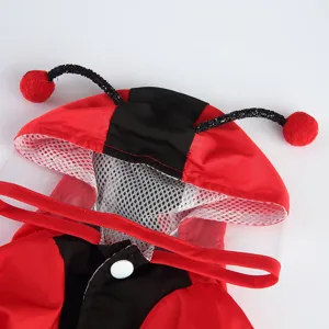 Détail de manteau de pluie mignon pour animal avec capuche rouge et noire et antennes d'insecte.