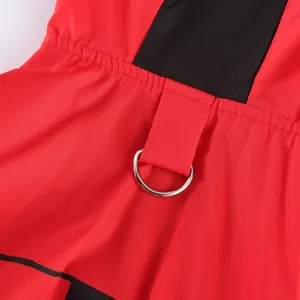 Détail de manteau de pluie pour animal avec tissu rouge imperméable et anneau en D en métal.