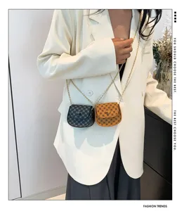 Bolso bandolera mini vintage con motivo de monograma sobre modelo con blazer blanco