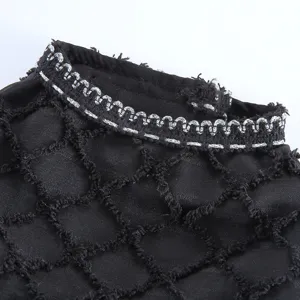 Detail de robe pour animal en maille noire avec bordure argente, chic et elegante pour fete.