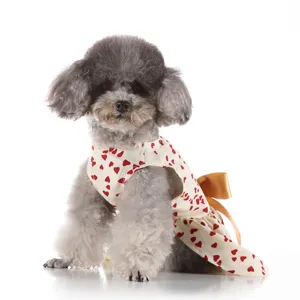 Detail view of cute dog summer dress with red heart print and elegant gold bow decoration.